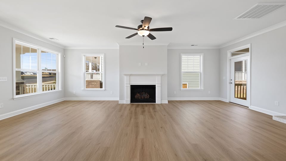 Family room with fireplace and ceiling fan.
