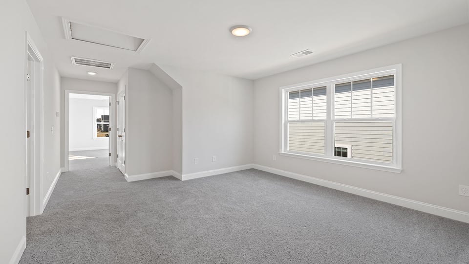 Loft area with carpet and windows.