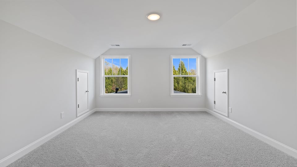 Loft area with carpet and windows.
