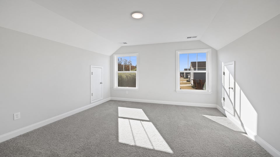 Loft area with carpet and windows.