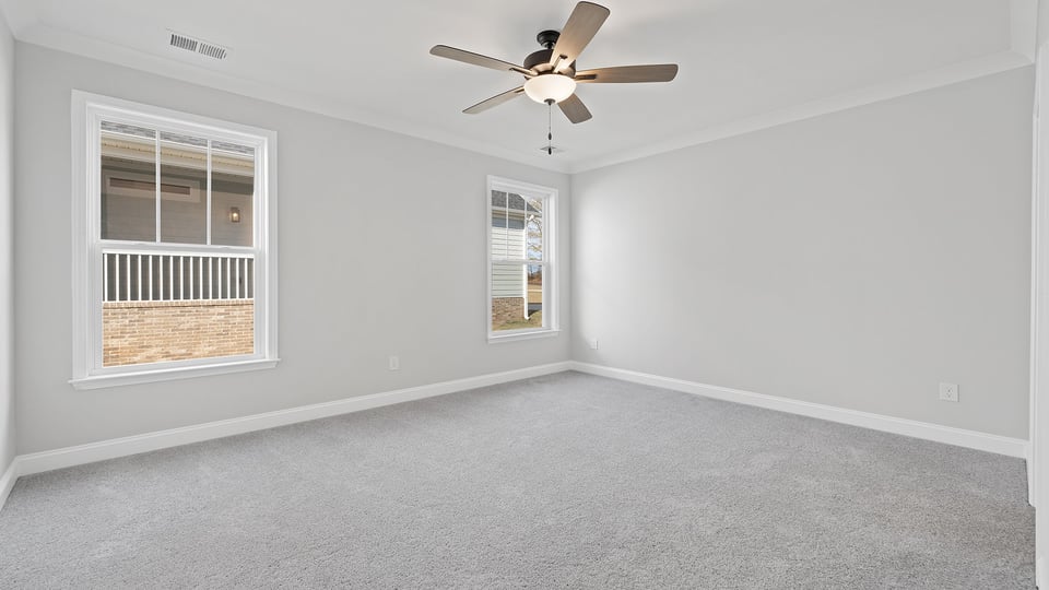 Bedroom with carpet and windows.