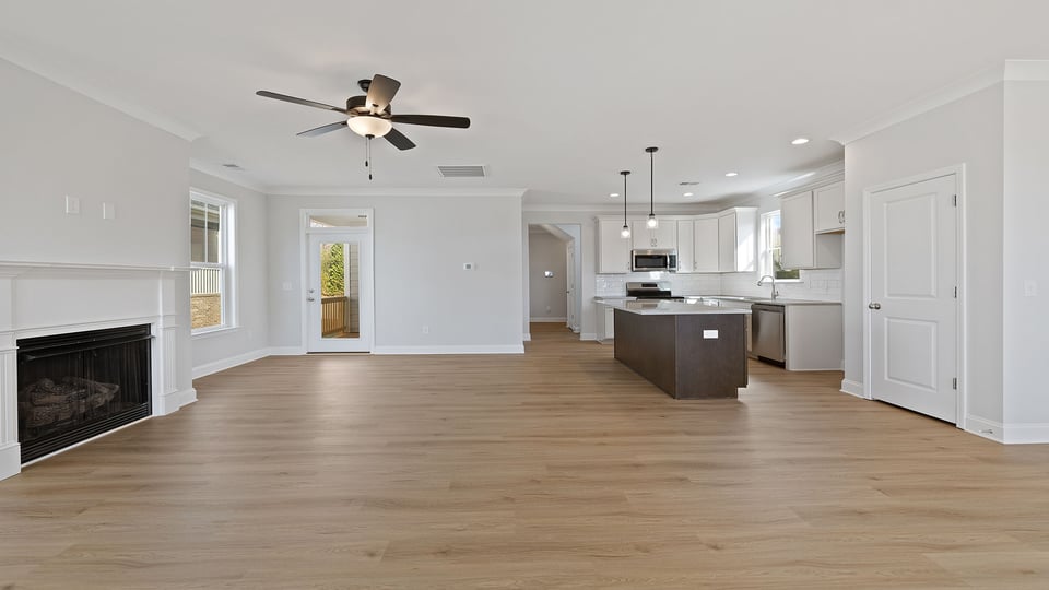 Family room with fireplace and ceiling fan.