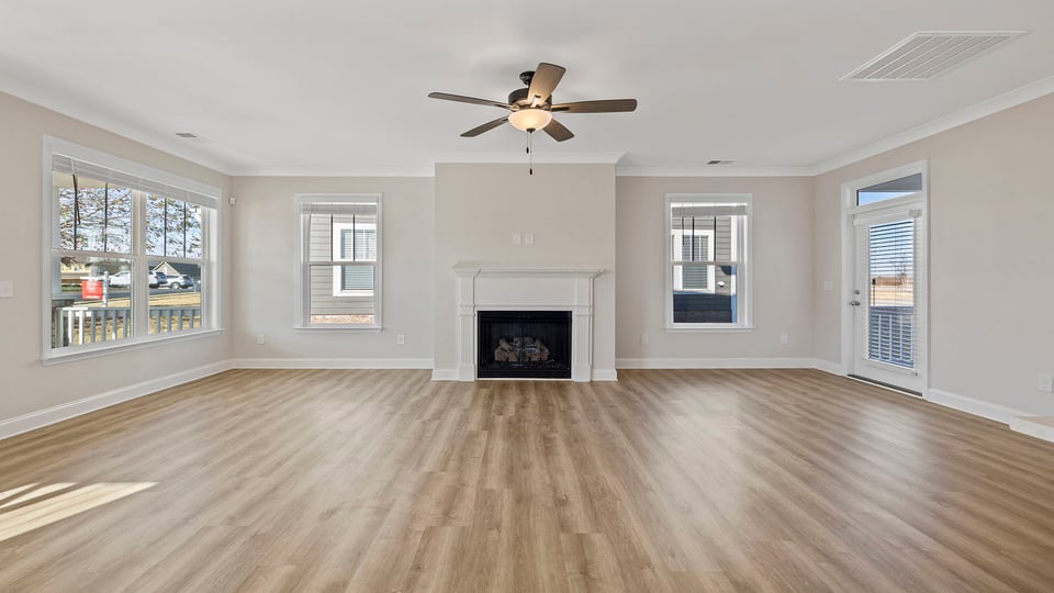 Family room with ceiling fan and fireplace.