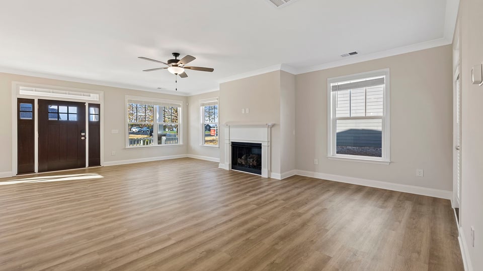 Family room with ceiling fan and fireplace.
