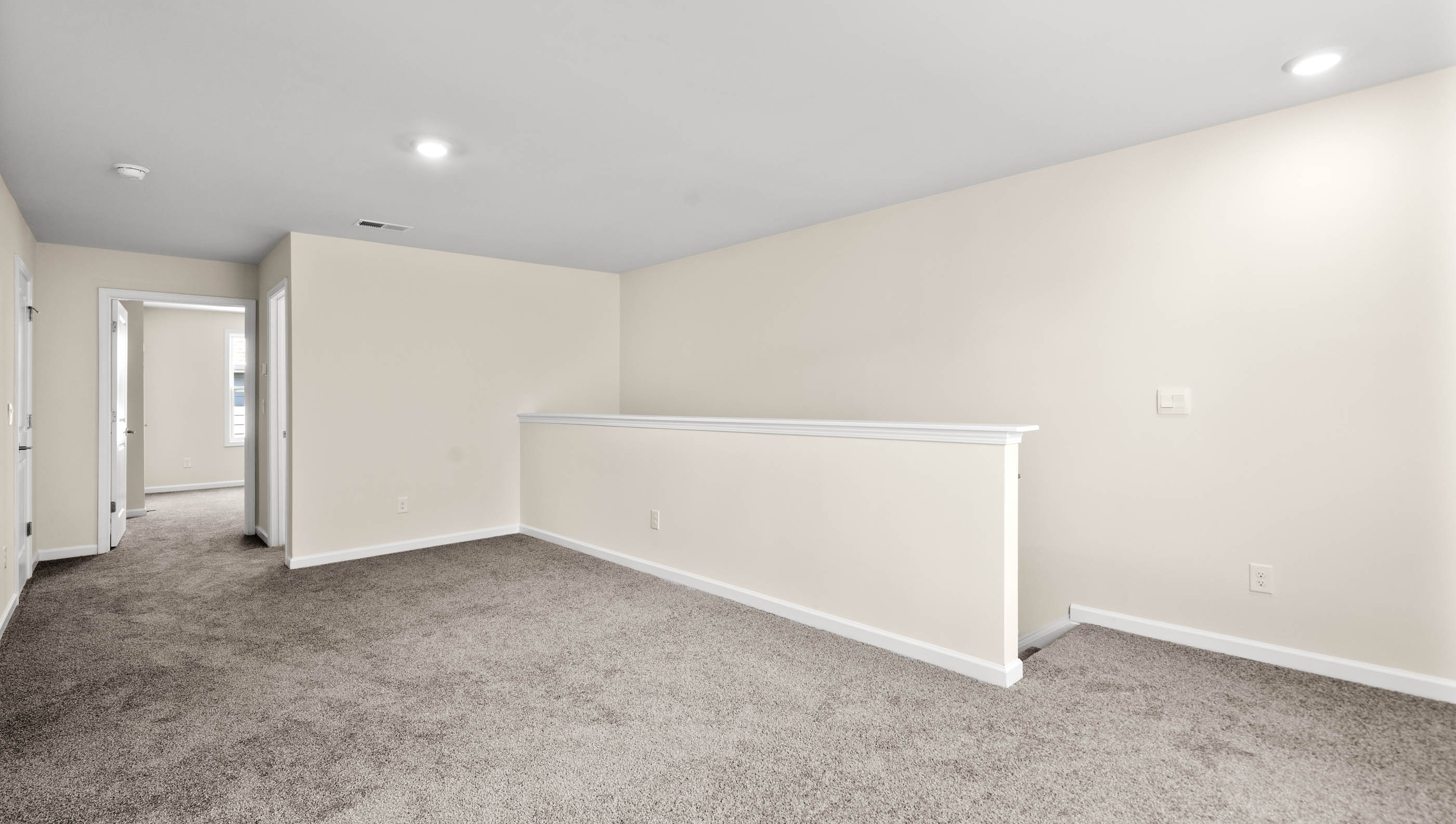 Loft area with carpet and windows.