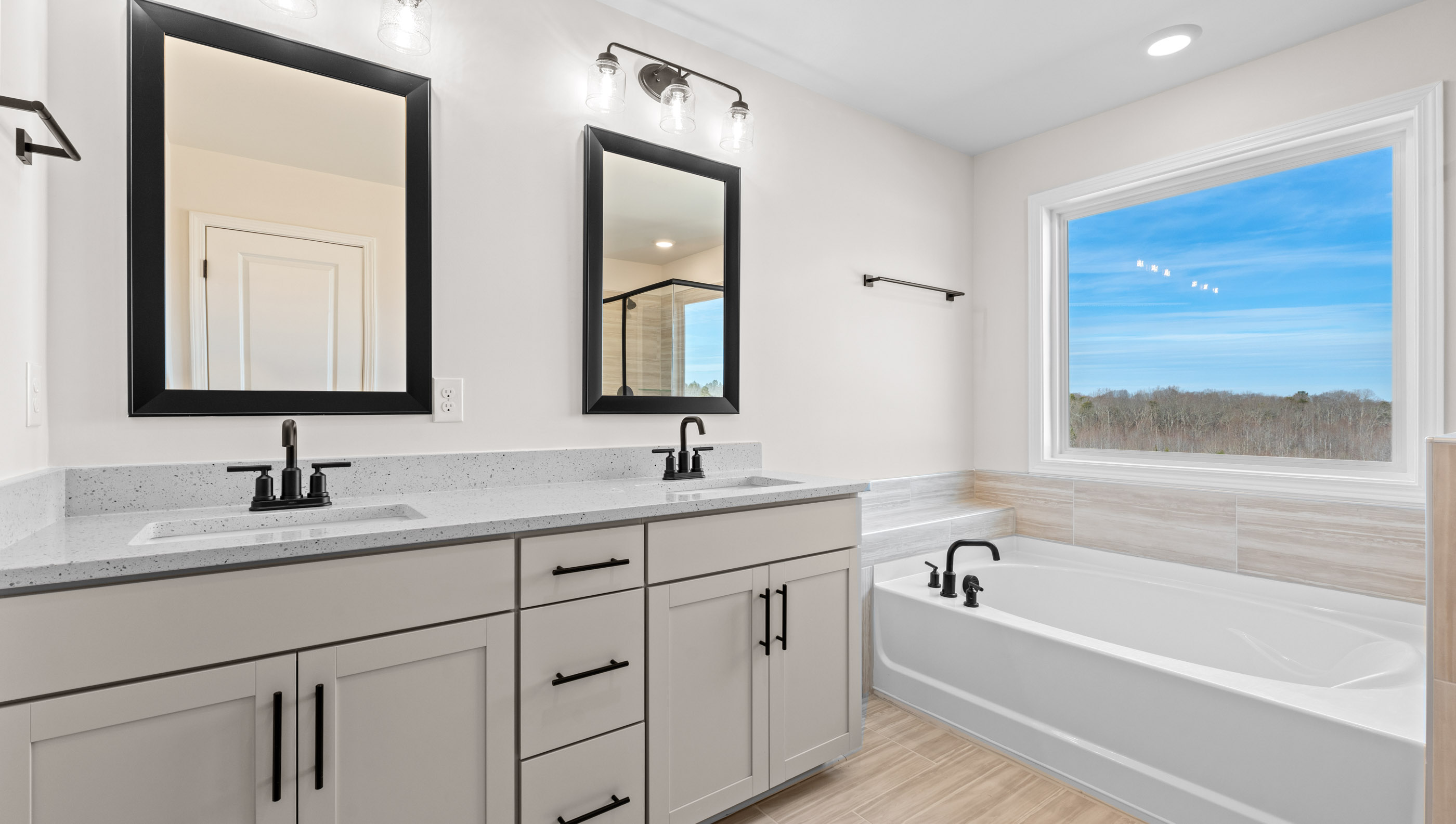 Bathroom with double vanity sink and tub.
