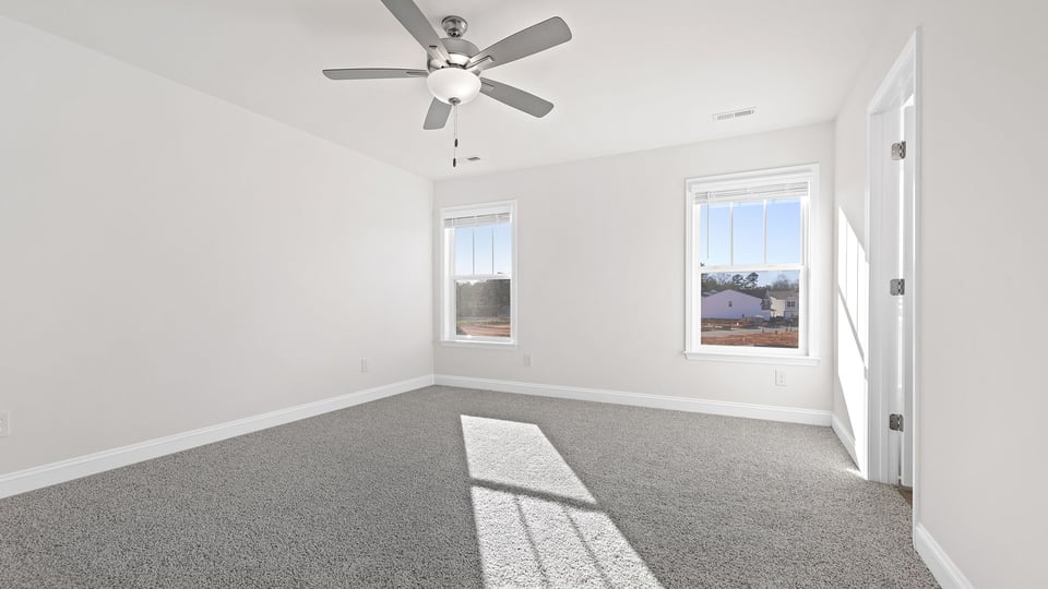 Bedroom with carpet and windows.