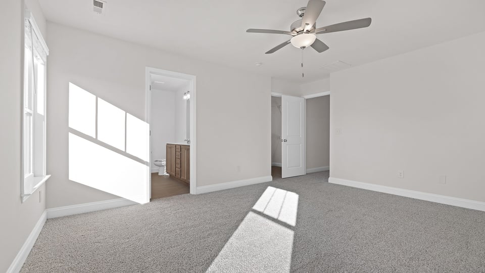 Bedroom with carpet and windows.