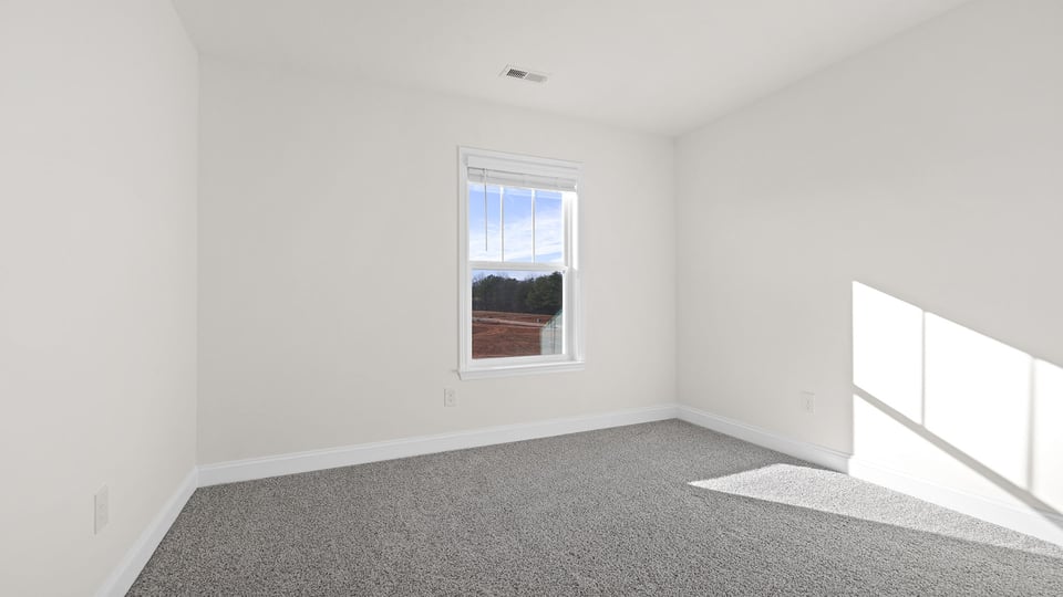 Bedroom with carpet and windows.