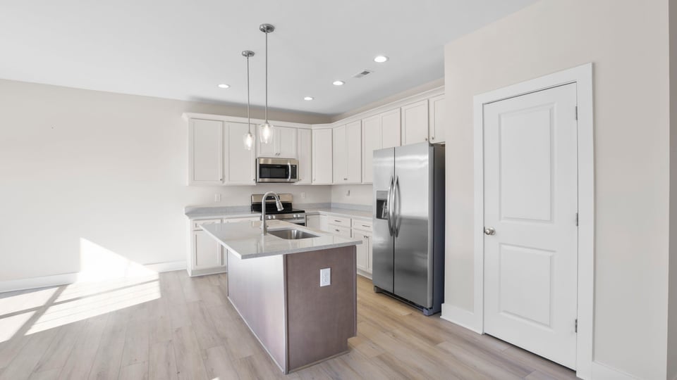 Kitchen with island and quartz countertops.