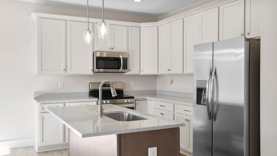 Kitchen with island and quartz countertops.