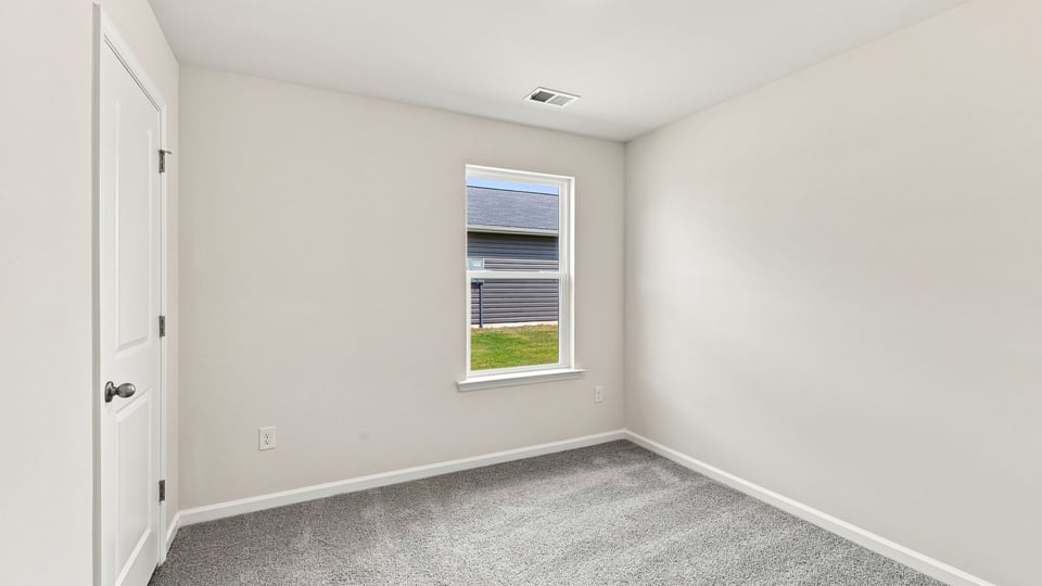 Bedroom with carpet and window.