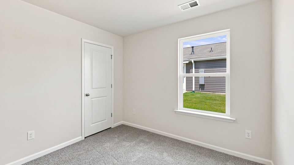 Bedroom with carpet and window.