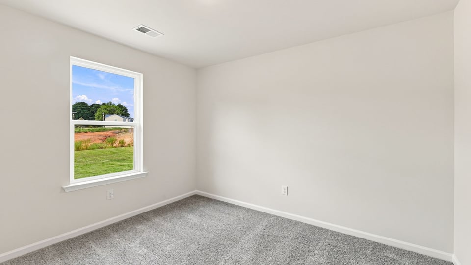 Bedroom with carpet and window.