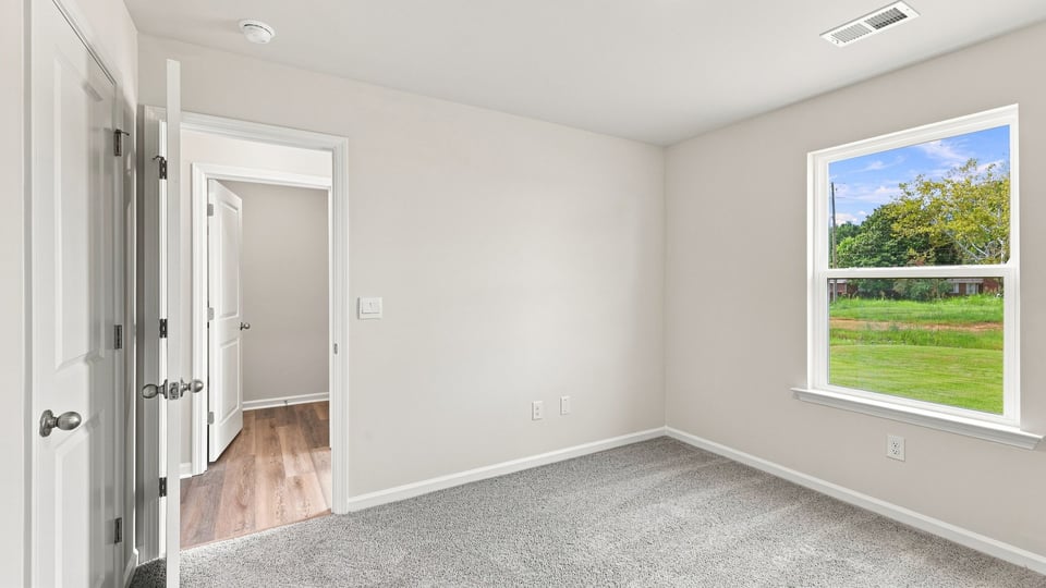Bedroom with carpet and window.
