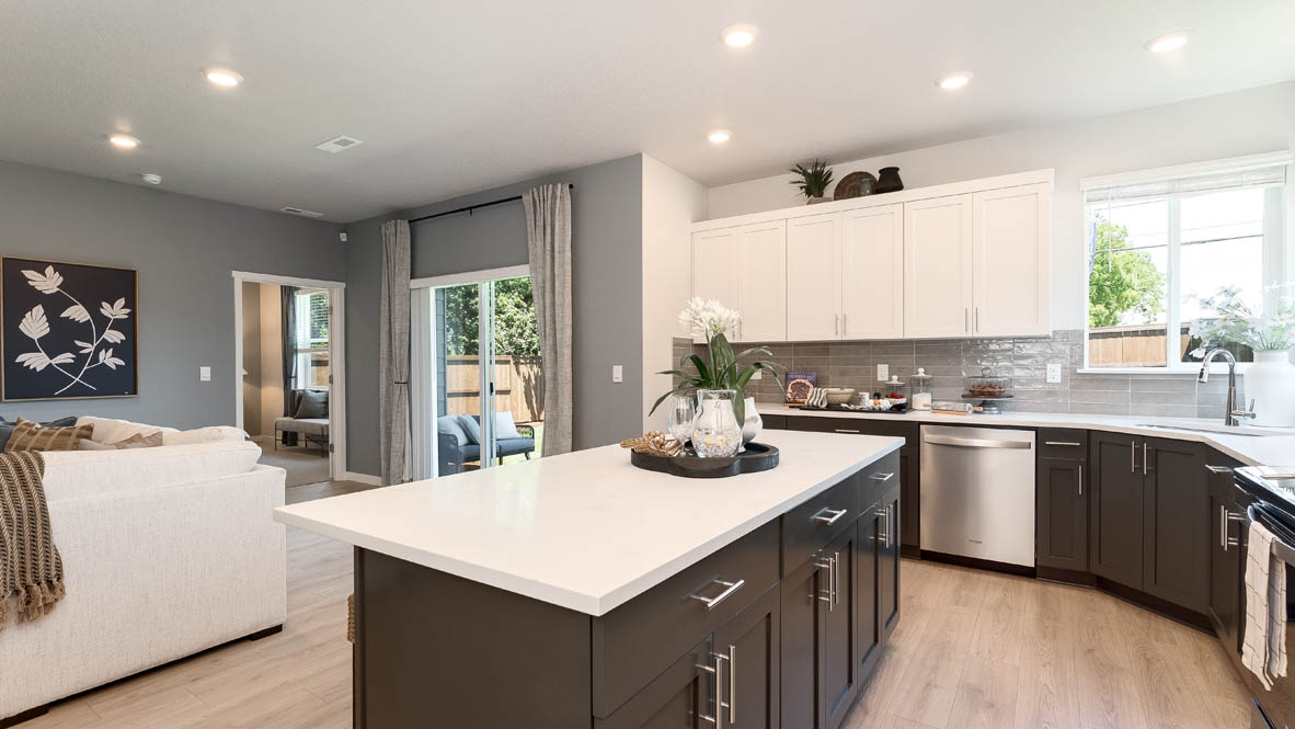 Landau Heights Kitchen with white solid surface countertops and stained shaker style cabinets and stainless steel appliances