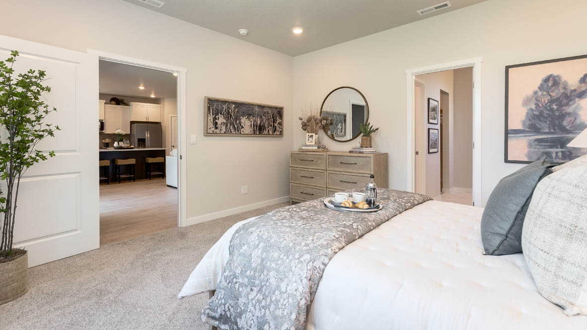 Landau Heights primary bedroom with carpeteing and an en suite laundry room and bathroom