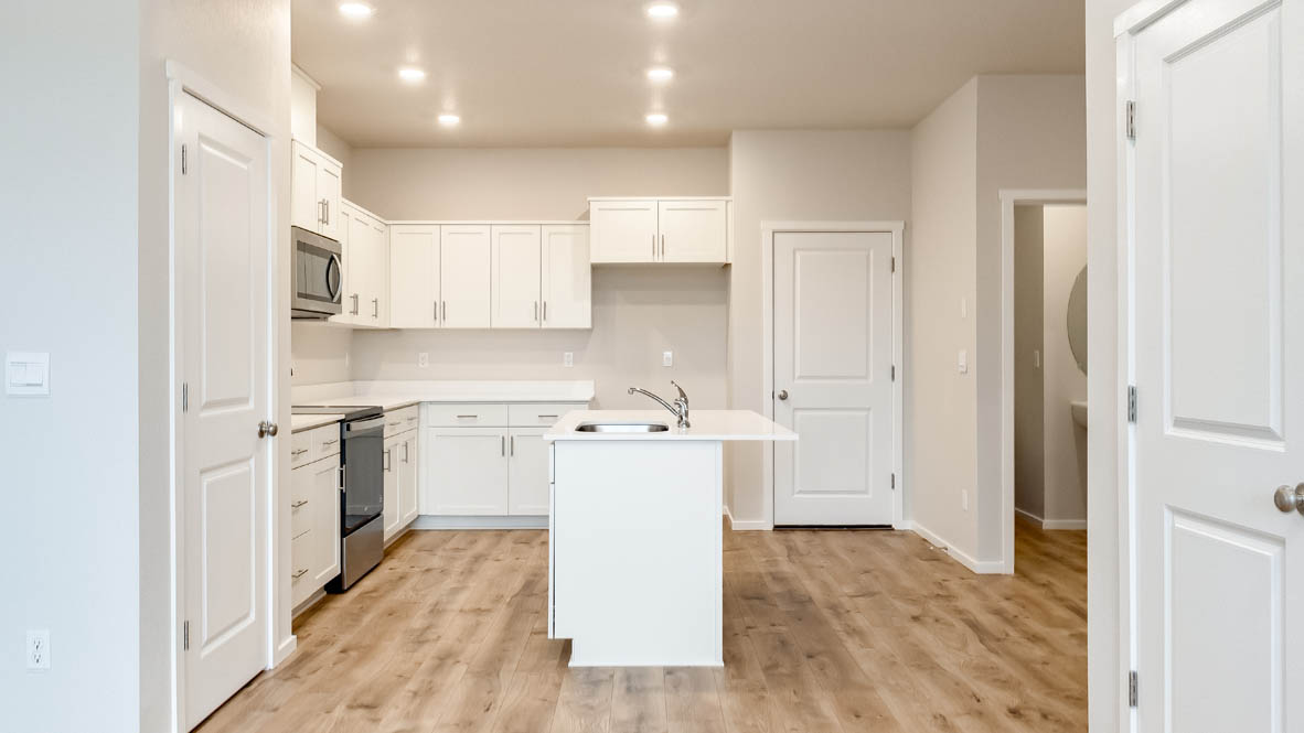 Terrace at Pleasant Valley Kitchen with laminate flooring, fireplace, island, stainless appliances, cabinets