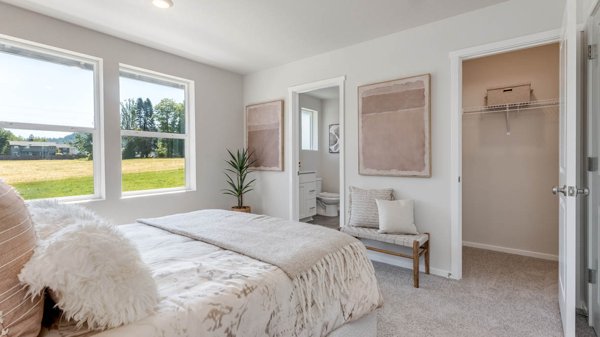 Terrace at Pleasant Valley Primary Bedroom with carpet, a bed with gray bedding, a table with a mirror above, and the primary bathroom in the background