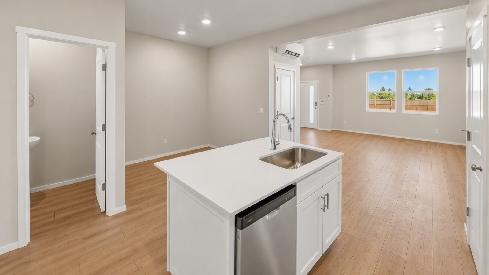Kitchen with shaker cabinets, quartz counters, stainless steel appliances, pantry, and an island with a breakfast bar