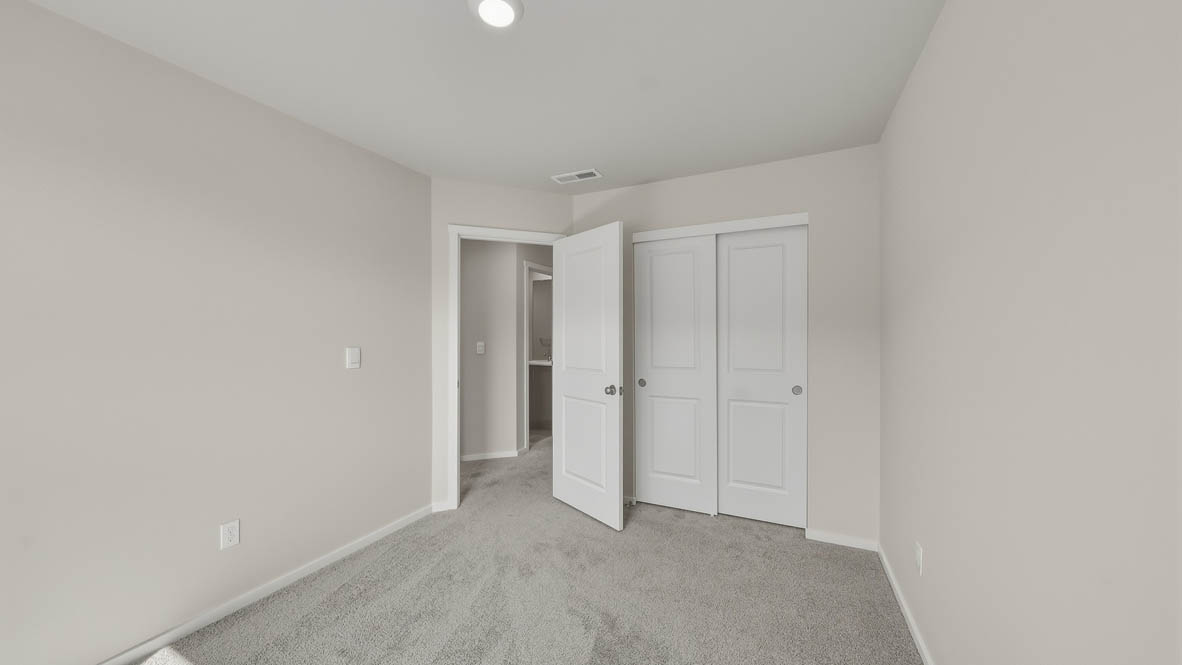Bedroom with wall-to-wall carpet and a closet