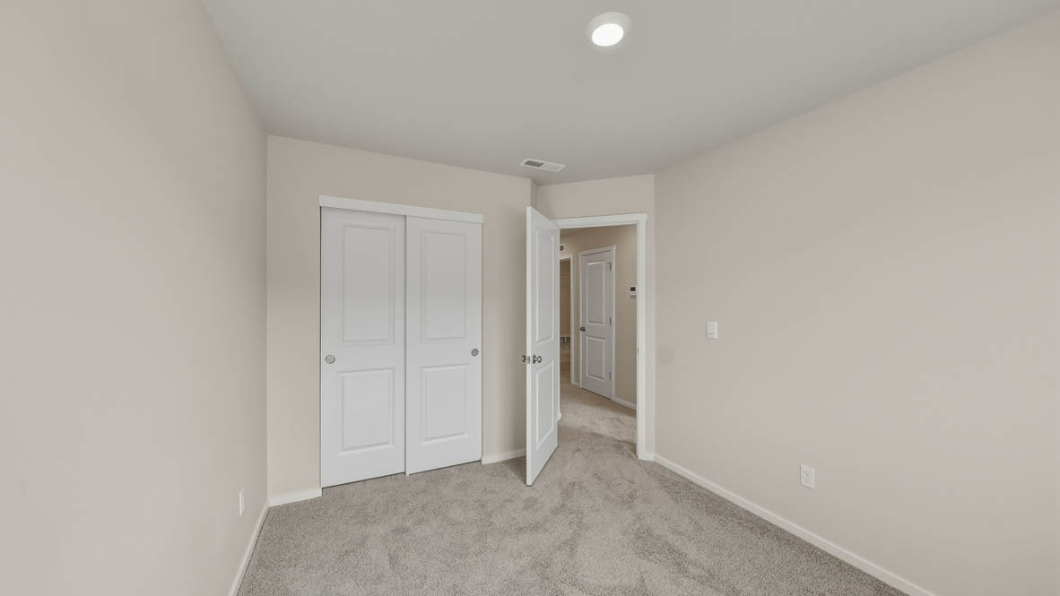 Bedroom with wall-to-wall carpet and a closet