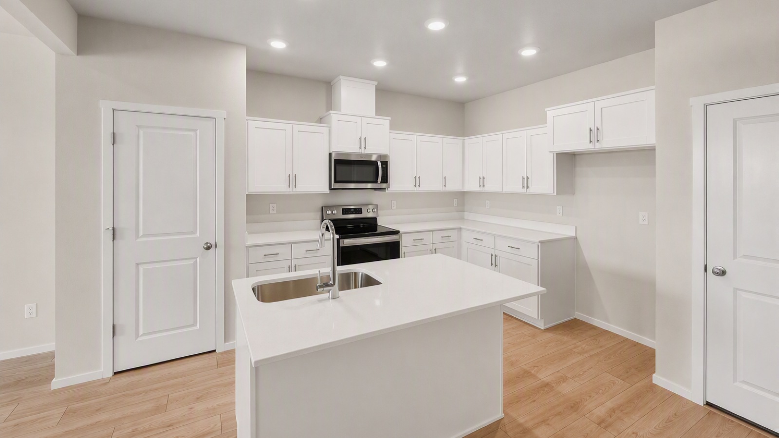 Kitchen with shaker cabinets, quartz counters, stainless steel appliances, pantry, and an island with a breakfast bar