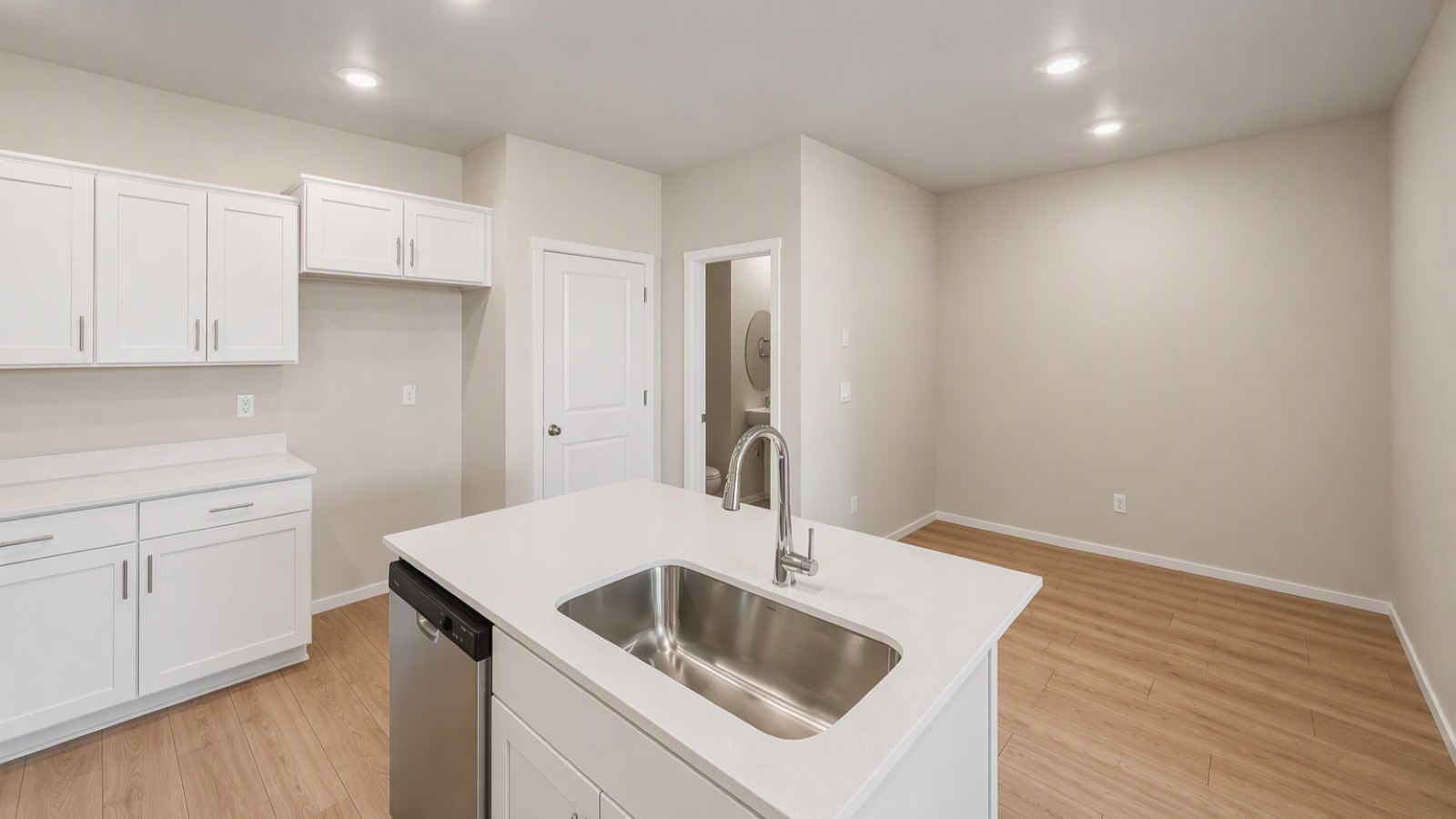 Kitchen with shaker cabinets, quartz counters, stainless steel appliances, pantry, and an island with a breakfast bar