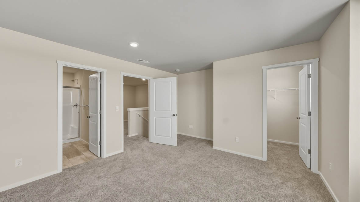 Primary bedroom with wall-to-wall carpet, a walk-in closet and an attached bathroom