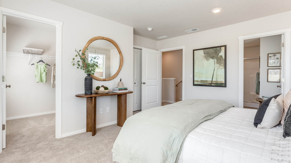 Terrace at Pleasant Valley Primary Bedroom with carpet, a bed with gray bedding, a table with a mirror above, and the primary bathroom in the background