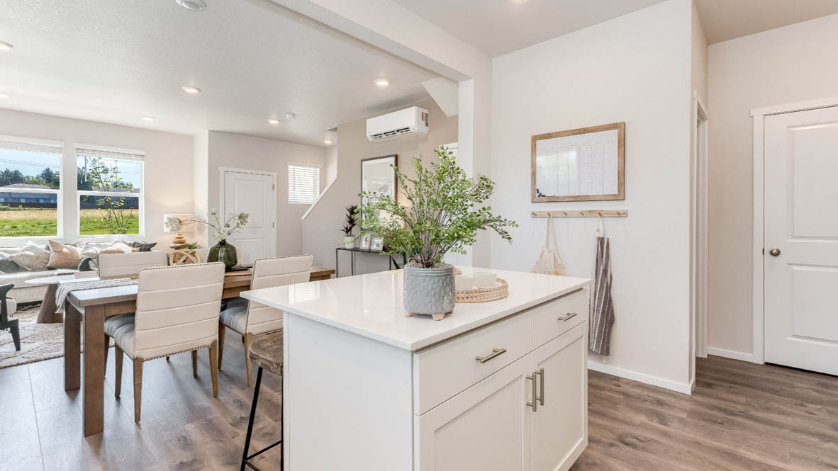 Kitchen with shaker cabinets, quartz counters, stainless steel appliances, pantry, and an island with a breakfast bar