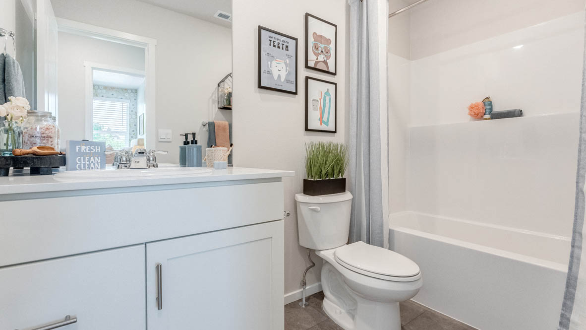 Hall bathroom with combination tub/shower and quartz counters