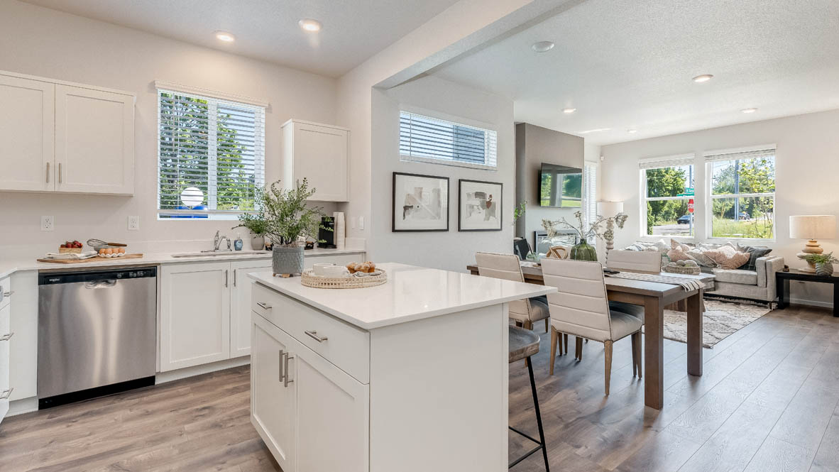 Kitchen with shaker cabinets, quartz counters, stainless steel appliances, pantry, and an island with a breakfast bar