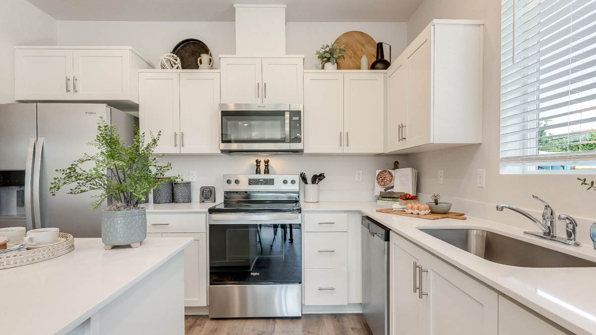 Terrace at Pleasant Valley Kitchen with an island, shaker style cabinets, solid surface countertops, stainless steel appliances, and a window