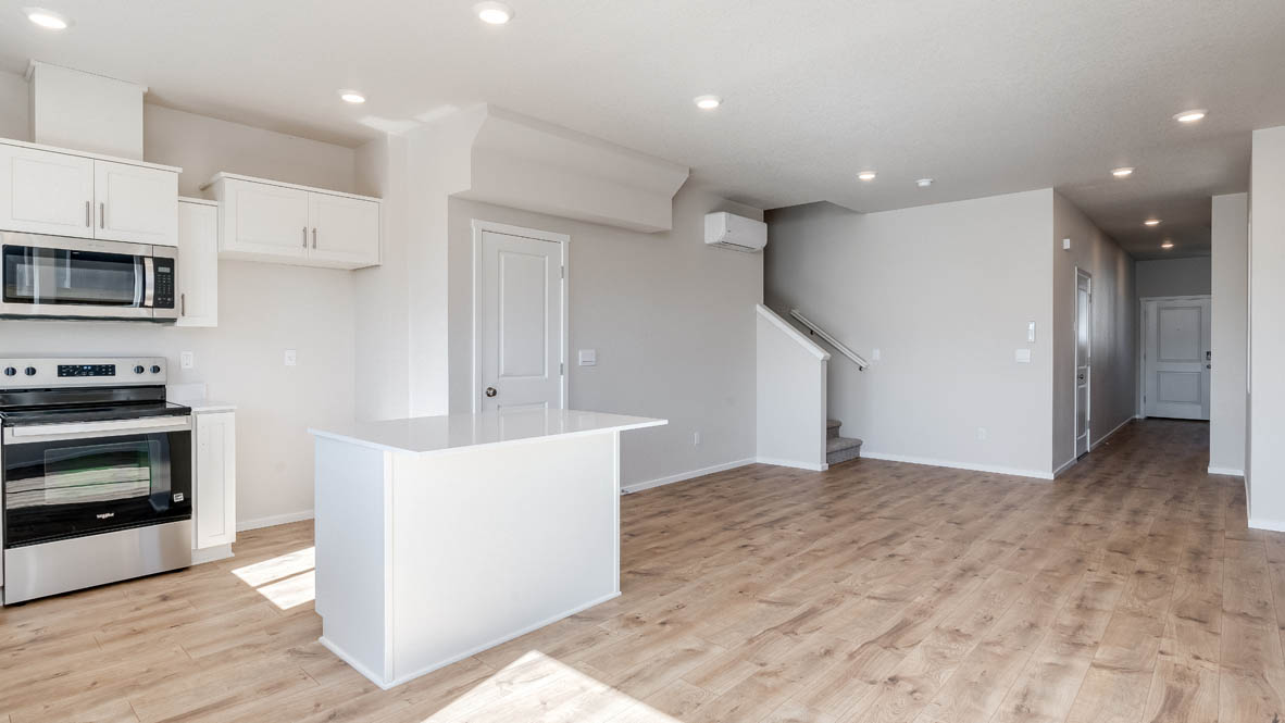 Terrace at Pleasant Valley kitchen and great room with stainless steel appliances, island, and staircase