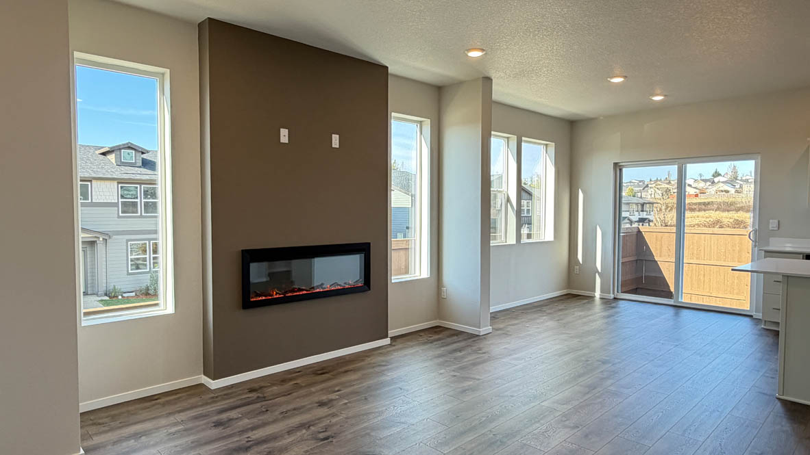 Terrace at Pleasant Valley great room and dining with fireplace, shiplap wall, kitchen island, and a sliding glass door