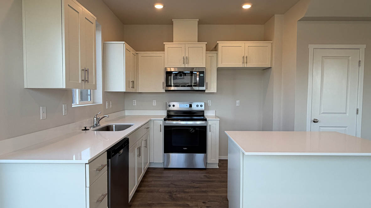Terrace at Pleasant Valley kitchen with stainless steel appliances, solid surface countertops, a window, and laminate flooring