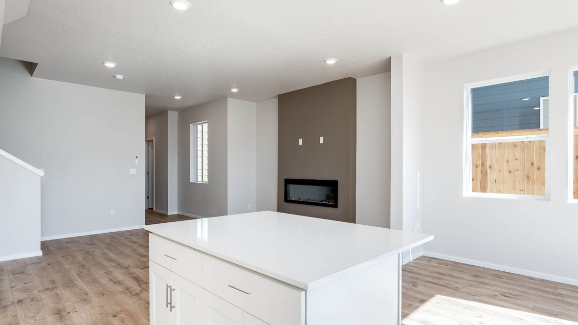 Terrace at Pleasant Valley kitchen and great room with laminate flooring, staircase, and the kitchen in the background
