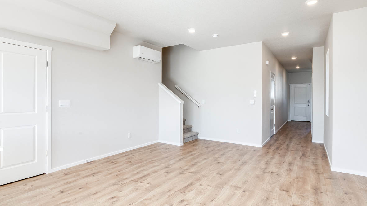 Terrace at Pleasant Valley great room with fireplace, shiplap wall, staircase, and the entry hallway in the background