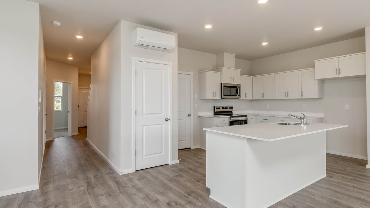 Terrace at Pleasant Valley kitchen with an island and white shaker style cabinets and laminate flooring and stainless steel appliances