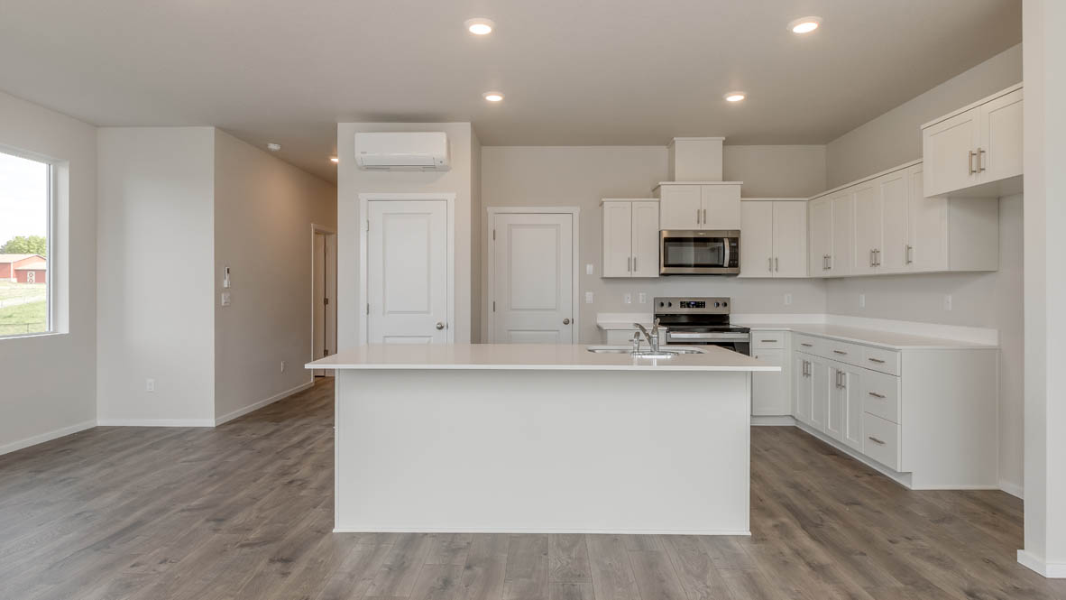 Terrace at Pleasant Valley kitchen with an island and white shaker style cabinets and laminate flooring and stainless steel appliances