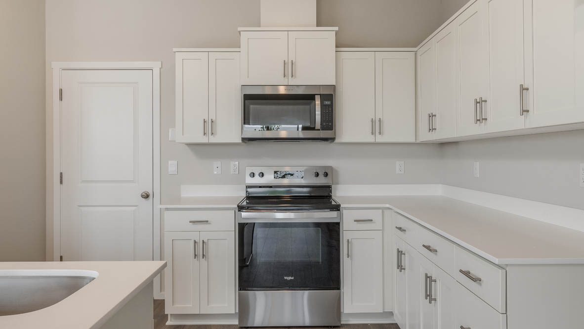 Terrace at Pleasant Valley kitchen with an island and white shaker style cabinets and laminate flooring and stainless steel appliances