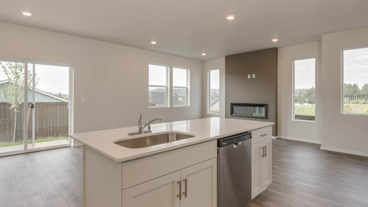 Terrace at Pleasant Valley kitchen with an island and white shaker style cabinets and laminate flooring and stainless steel appliances next to great room