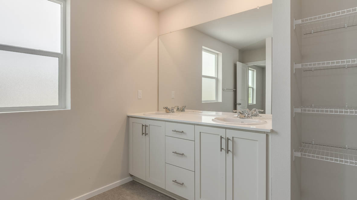Terrace at Pleasant Valley primary bathroom with double sink vanity and white shaker style cabinets and linen closet
