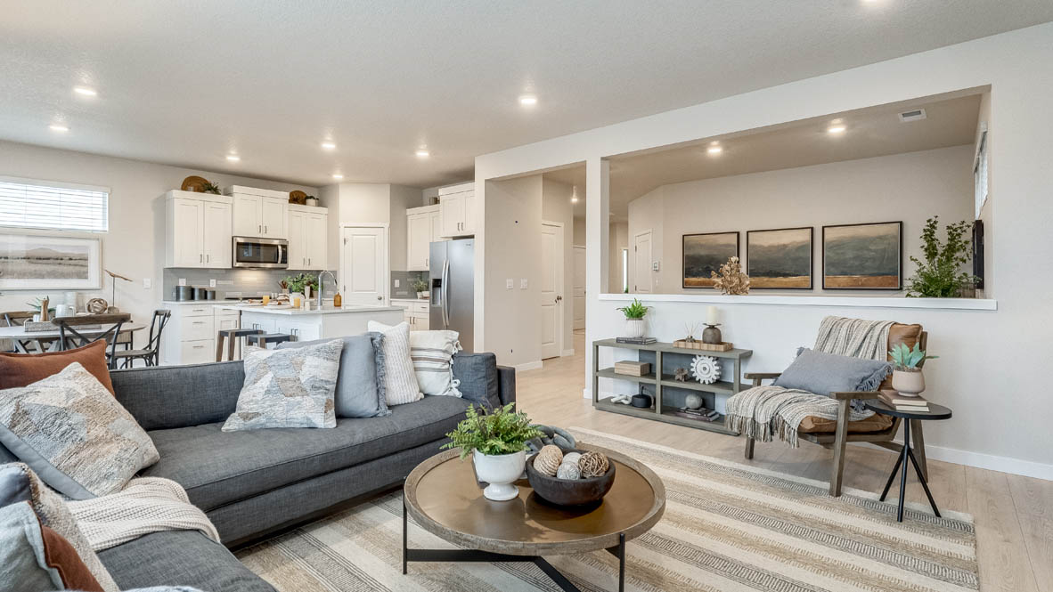 Butler Creek Crossing Great room with L shaped sectional couch facing the fireplace and TV over an area rug with a coffee table and chair in the corner