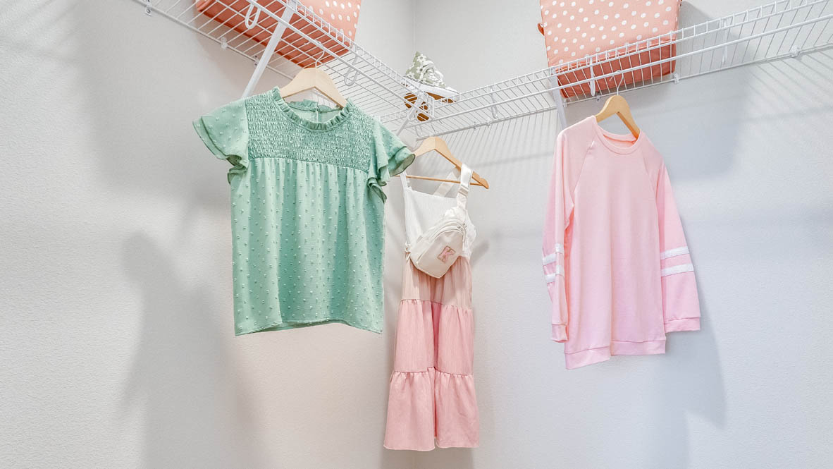 Butler Creek Crossing closet with white wire shelving, and three hung up dresses