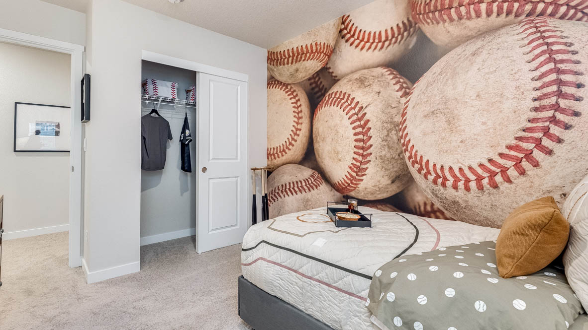 Butler Creek Crossing bedroom with side table and a lamp, bed, paintings, desk with a chair, and closet