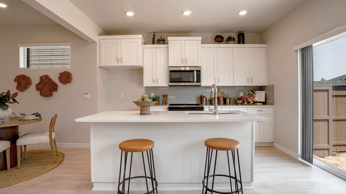 Butler Creek Crossing kitchen with shaker style cabinets and white solid surface countertops and full height backsplash