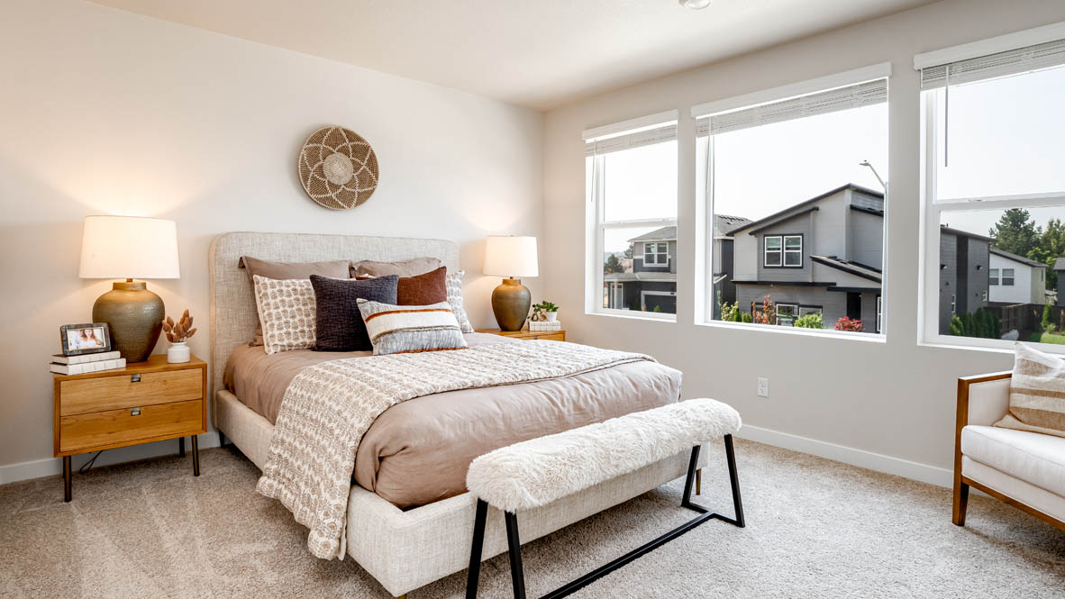 Butler Creek Crossing primary bedroom with large bed and two side tables and en suite bathroom