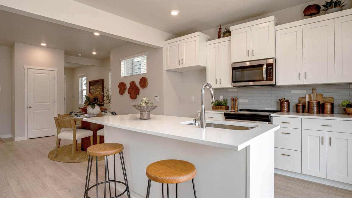 Butler Creek Crossing kitchen with shaker style cabinets and white solid surface countertops and full height backsplash